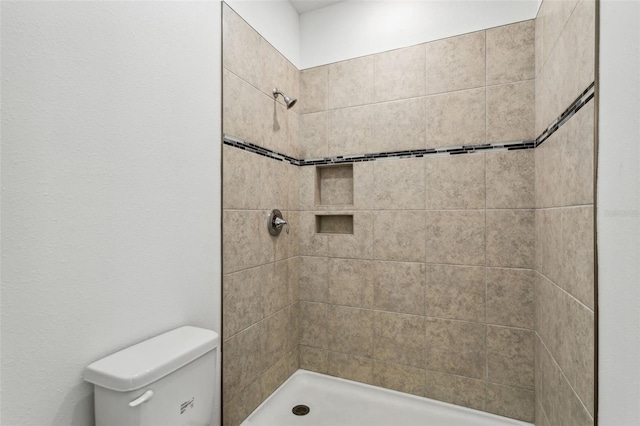 bathroom featuring toilet and tiled shower