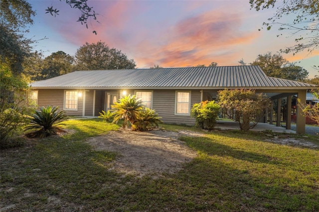 back house at dusk with a lawn