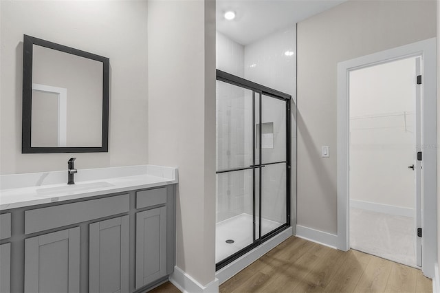 bathroom featuring vanity, hardwood / wood-style flooring, and a shower with shower door