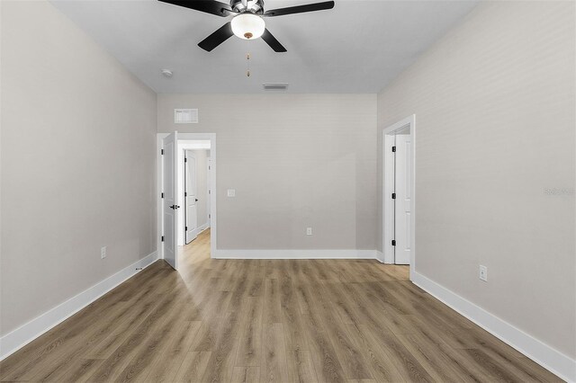 spare room with ceiling fan and light wood-type flooring