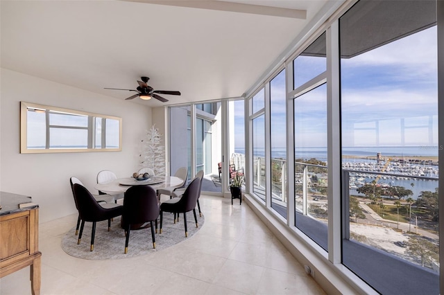 sunroom / solarium with a water view and ceiling fan