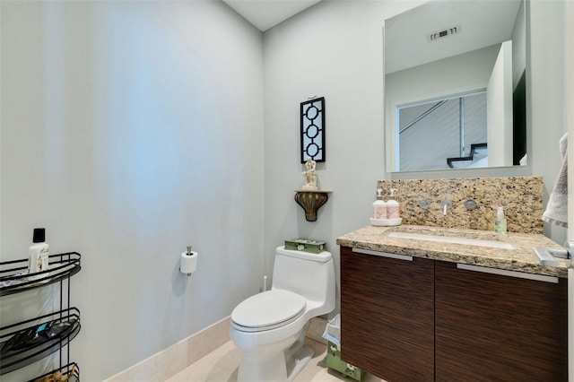 bathroom with vanity, toilet, and tile patterned floors