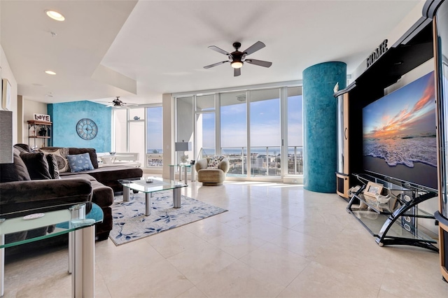 living room featuring expansive windows, a healthy amount of sunlight, and ceiling fan