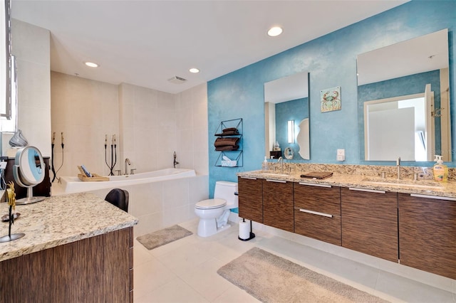 bathroom featuring tile patterned floors, toilet, vanity, a relaxing tiled tub, and tile walls