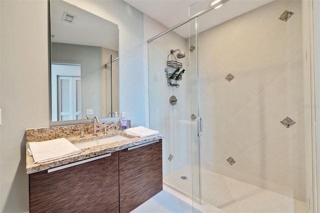 bathroom featuring vanity, a shower with shower door, and tile patterned flooring