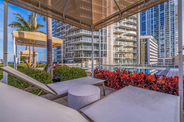 view of patio featuring a balcony and a community pool