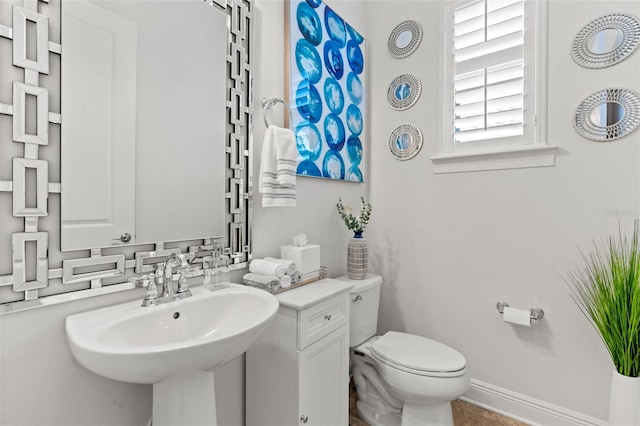 bathroom featuring toilet, sink, and backsplash