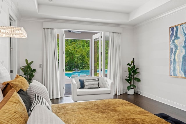 living area featuring dark hardwood / wood-style floors, a tray ceiling, and ceiling fan