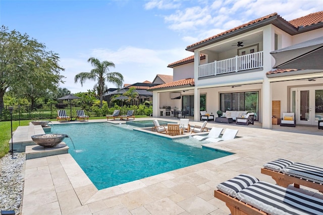 view of swimming pool with a patio, french doors, an outdoor hangout area, ceiling fan, and pool water feature