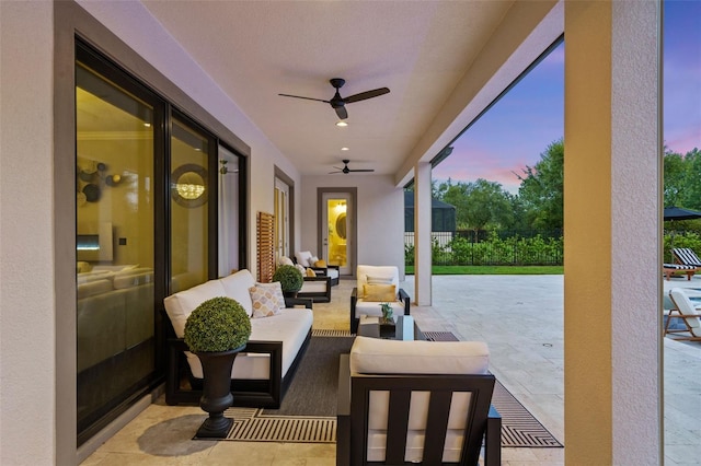 patio terrace at dusk featuring an outdoor living space and ceiling fan