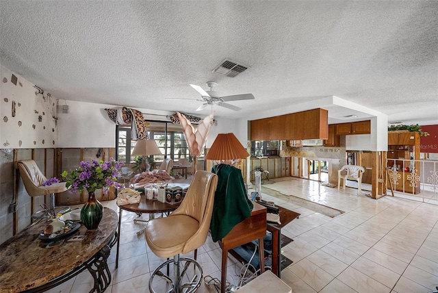 living room with ceiling fan and a textured ceiling