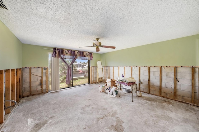 miscellaneous room with ceiling fan and a textured ceiling