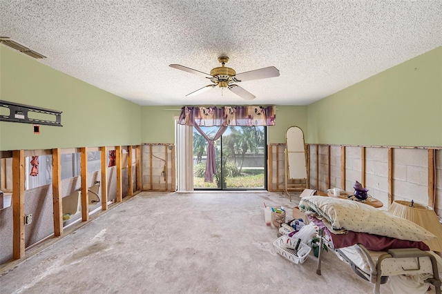 interior space with a textured ceiling, carpet floors, and ceiling fan