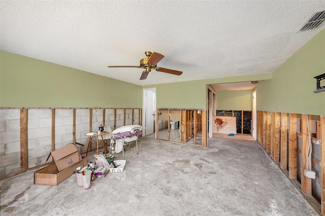 interior space with ceiling fan, a textured ceiling, and carpet floors