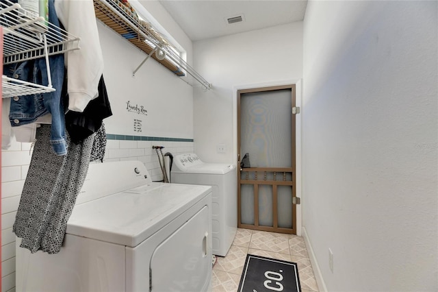 clothes washing area with tile walls and washing machine and clothes dryer