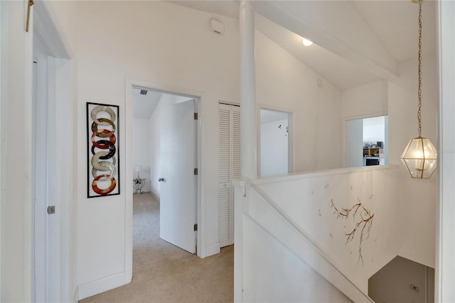 hallway featuring light carpet and vaulted ceiling