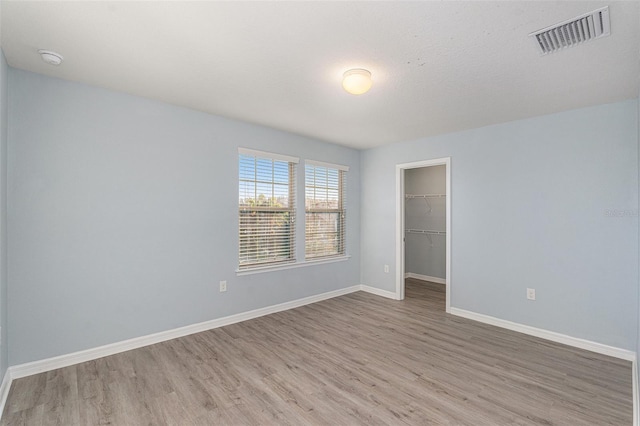 empty room featuring light hardwood / wood-style flooring and a textured ceiling