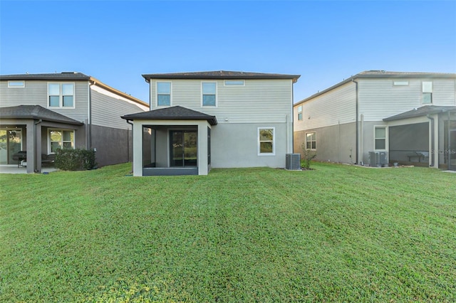 back of property with cooling unit, a yard, and a sunroom