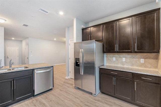 kitchen featuring sink, dark brown cabinetry, stainless steel appliances, and light hardwood / wood-style floors