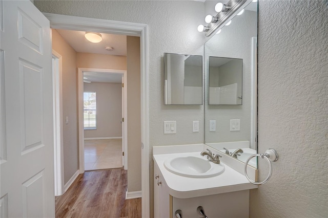 3776 Junction St, North Port, FL 34288 - bathroom featuring vanity, wood finished floors, a textured wall, and baseboards