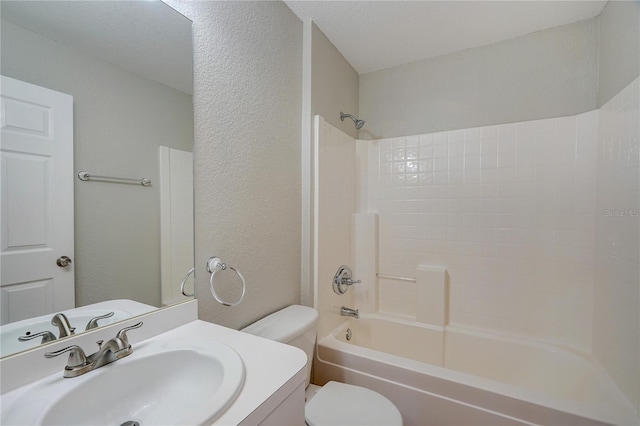 full bathroom with vanity, tub / shower combination, a textured ceiling, and toilet