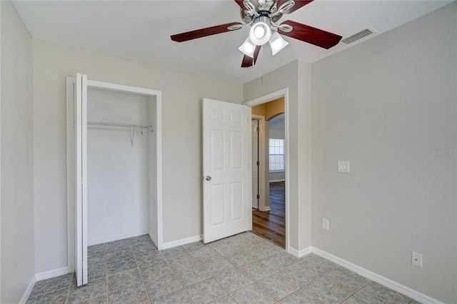 unfurnished bedroom featuring ceiling fan, a closet, and light tile patterned flooring