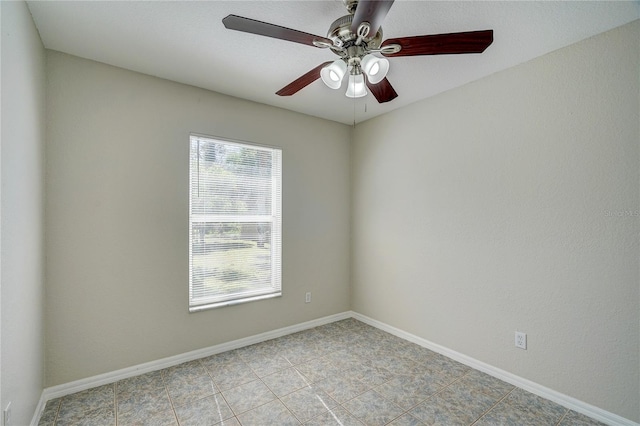 empty room with ceiling fan and light tile patterned flooring