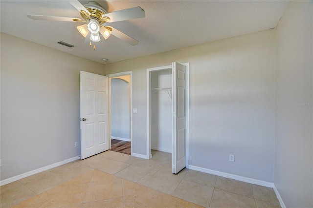 unfurnished bedroom featuring ceiling fan, a closet, and light tile patterned flooring