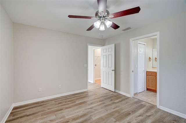 unfurnished bedroom with ceiling fan, ensuite bathroom, and light wood-type flooring