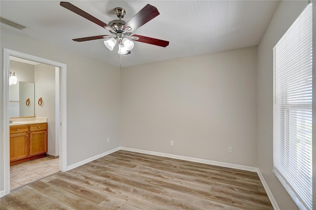3776 Junction St, North Port, FL 34288 - unfurnished bedroom with light wood finished floors, baseboards, ensuite bath, and ceiling fan