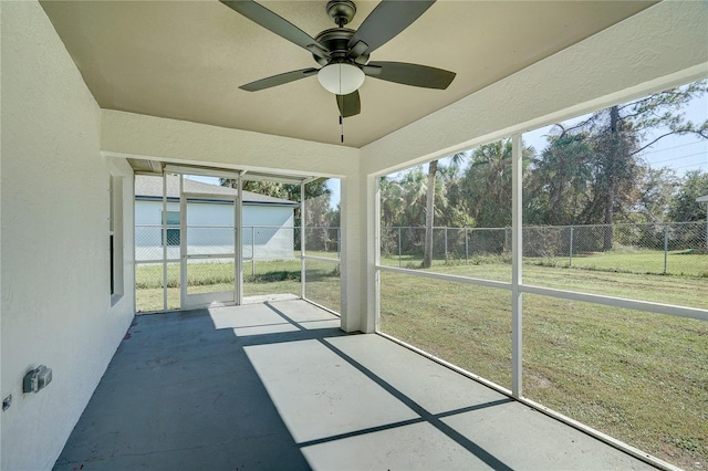 unfurnished sunroom featuring ceiling fan