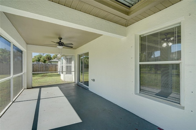 unfurnished sunroom featuring ceiling fan