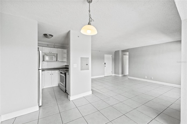 unfurnished living room featuring light tile patterned floors, a textured ceiling, baseboards, and electric panel
