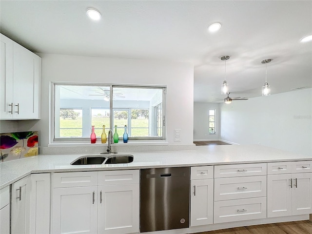 kitchen featuring dishwasher, sink, hanging light fixtures, white cabinetry, and hardwood / wood-style floors