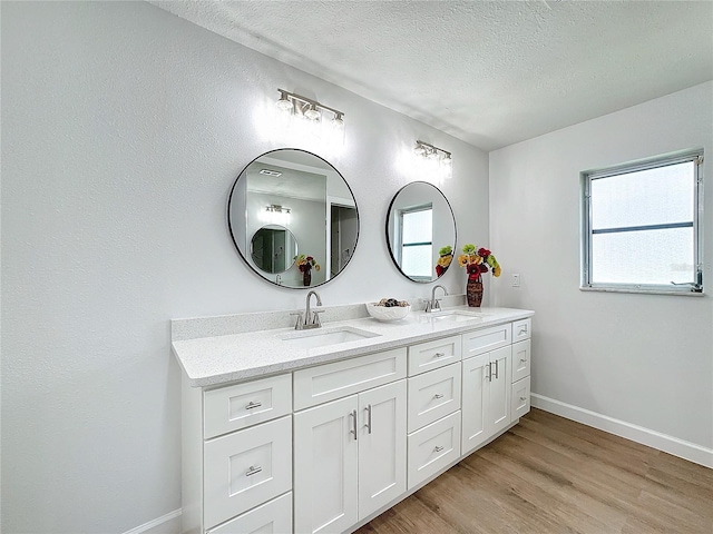 bathroom with vanity, a textured ceiling, and hardwood / wood-style flooring