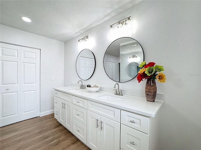 bathroom featuring vanity, hardwood / wood-style floors, and a textured ceiling