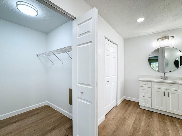 bathroom with vanity, hardwood / wood-style flooring, and a textured ceiling