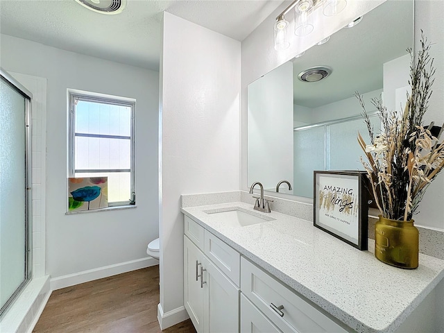 bathroom featuring vanity, toilet, walk in shower, and wood-type flooring