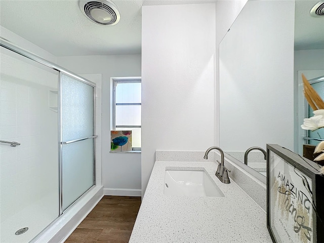 bathroom with vanity, walk in shower, and wood-type flooring