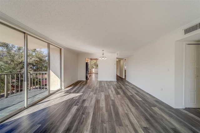 unfurnished living room with expansive windows, a notable chandelier, a textured ceiling, and dark hardwood / wood-style flooring