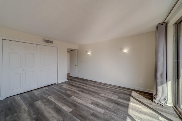 unfurnished bedroom featuring hardwood / wood-style flooring and a closet