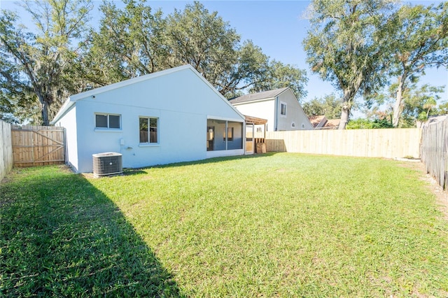 back of property featuring central AC and a lawn