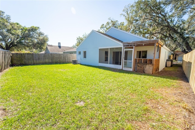 back of property featuring a yard and central air condition unit