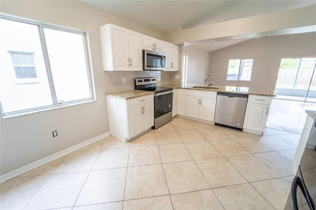 kitchen with white cabinetry, sink, stainless steel appliances, kitchen peninsula, and lofted ceiling