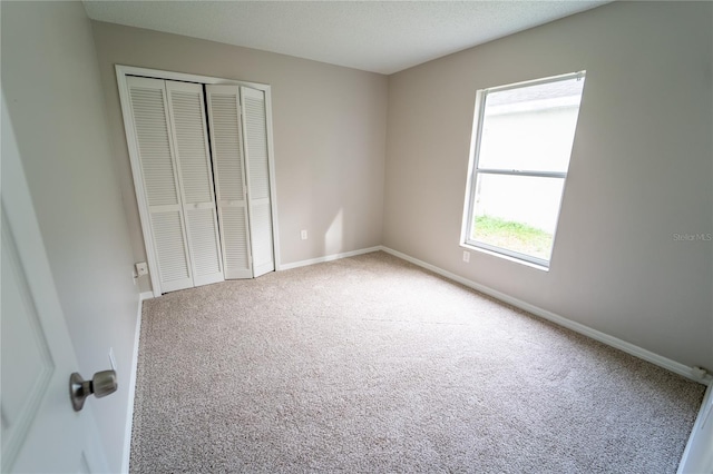 unfurnished bedroom featuring carpet flooring and a closet