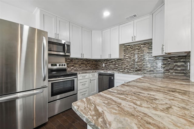 kitchen with light stone countertops, appliances with stainless steel finishes, dark hardwood / wood-style floors, and white cabinetry