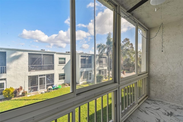 unfurnished sunroom with ceiling fan