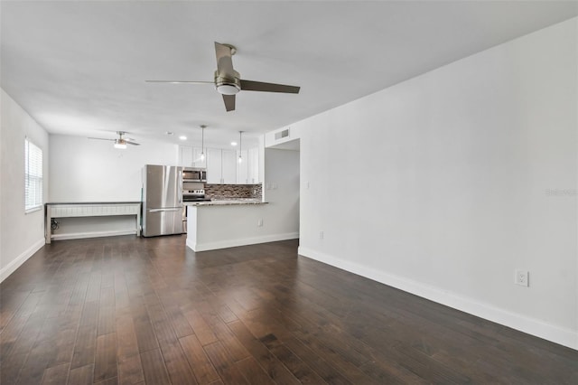 unfurnished living room with dark hardwood / wood-style floors and ceiling fan