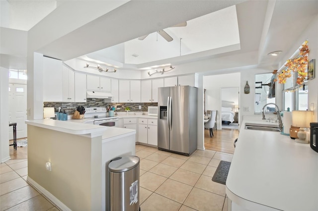 kitchen featuring white appliances, sink, backsplash, ceiling fan, and white cabinets