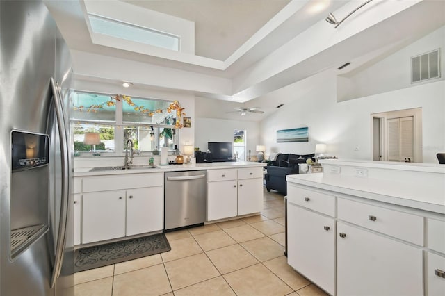 kitchen with appliances with stainless steel finishes, white cabinets, plenty of natural light, and ceiling fan